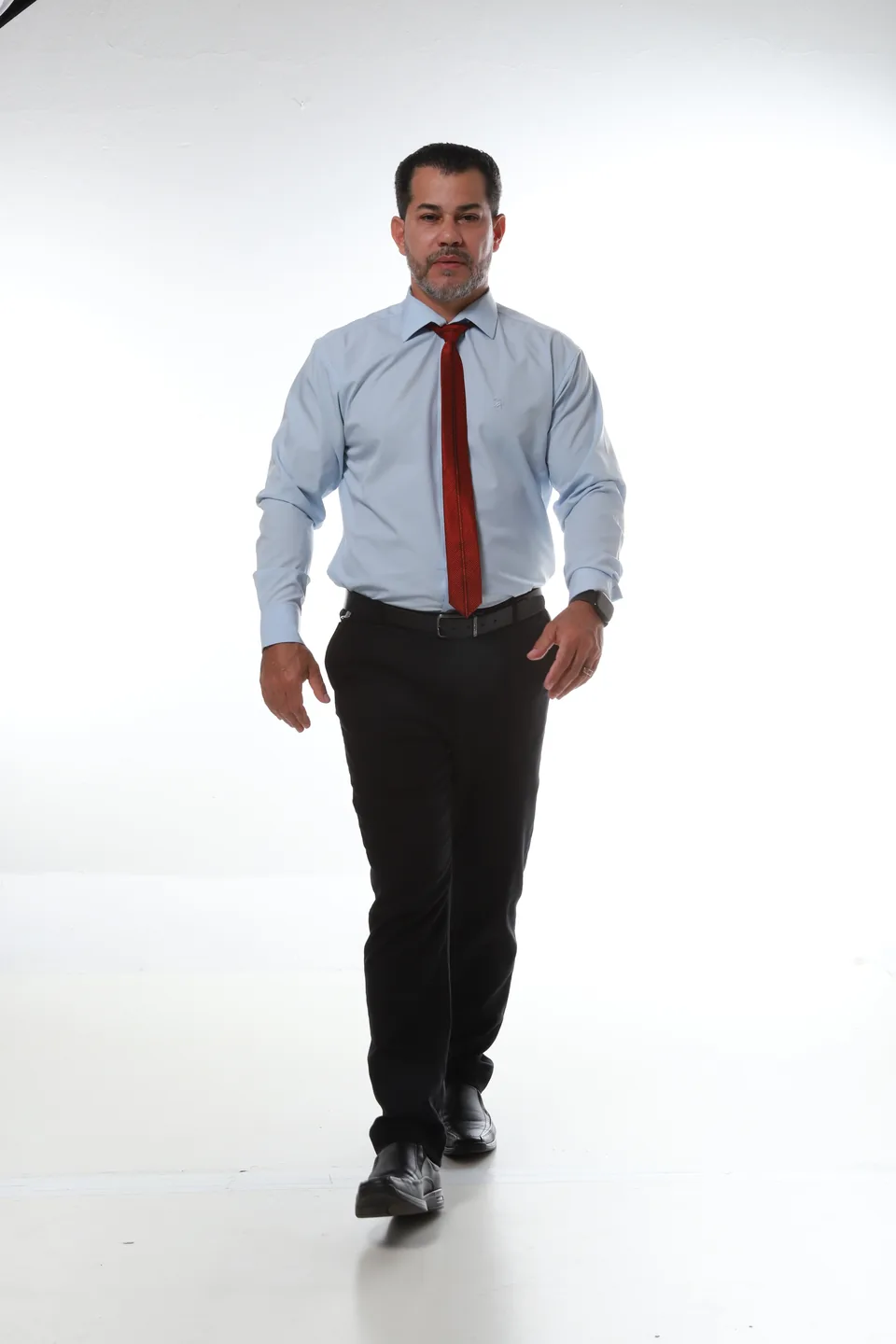 Nilton Souza caminhando, vestindo camisa social e gravata